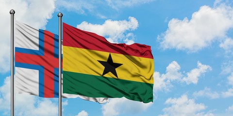Faroe Islands and Ghana flag waving in the wind against white cloudy blue sky together. Diplomacy concept, international relations.
