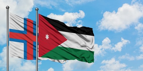 Faroe Islands and Jordan flag waving in the wind against white cloudy blue sky together. Diplomacy concept, international relations.