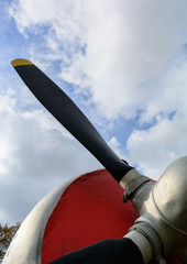 Part of the fuselage of the old military plane with the propeller closeup against the background of...
