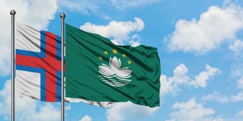 Faroe Islands and Macao flag waving in the wind against white cloudy blue sky together. Diplomacy concept, international relations.