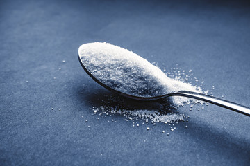 Minimalist flat lay composition sugar and spoon on the dark background. Medical, Healthcare and...