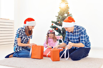 Holidays and presents concept - Portrait of a happy family opening gifts at Christmas time