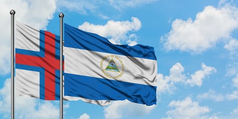Faroe Islands and Nicaragua flag waving in the wind against white cloudy blue sky together. Diplomacy concept, international relations.