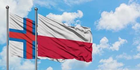 Faroe Islands and Poland flag waving in the wind against white cloudy blue sky together. Diplomacy concept, international relations.