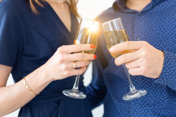 Close-up of man and woman celebrating Christmas or New Year eve party with glasses of champagne.