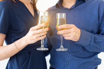 Close-up of man and woman celebrating Christmas or New Year eve party with glasses of champagne.