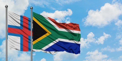 Faroe Islands and South Africa flag waving in the wind against white cloudy blue sky together. Diplomacy concept, international relations.
