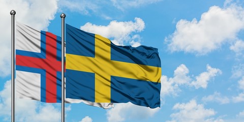 Faroe Islands and Sweden flag waving in the wind against white cloudy blue sky together. Diplomacy concept, international relations.