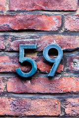 metal number 59 on brick wall