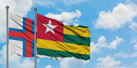 Faroe Islands and Togo flag waving in the wind against white cloudy blue sky together. Diplomacy concept, international relations.