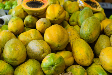 Heap of papaya fruits in a market, close up.