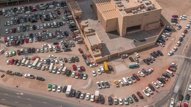 Aerial view full cars at large outdoor parking lots timelapse in Dubai, UAE. Office and recidential parking congestion and crowded parking lot with other cars try getting in and out, finding parking