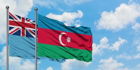 Fiji and Azerbaijan flag waving in the wind against white cloudy blue sky together. Diplomacy concept, international relations.