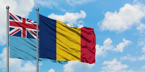 Fiji and Chad flag waving in the wind against white cloudy blue sky together. Diplomacy concept, international relations.
