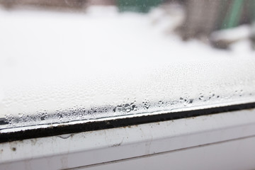 mold on a foggy plastic window of white color. Close-up