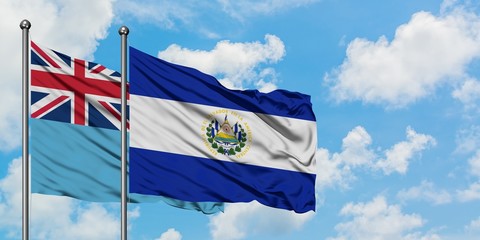 Fiji and El Salvador flag waving in the wind against white cloudy blue sky together. Diplomacy concept, international relations.