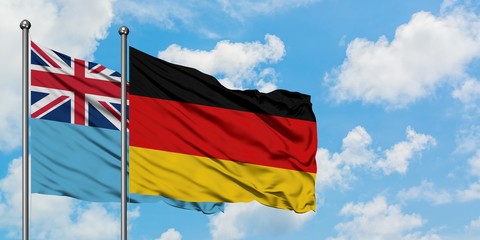 Fiji and Germany flag waving in the wind against white cloudy blue sky together. Diplomacy concept, international relations.