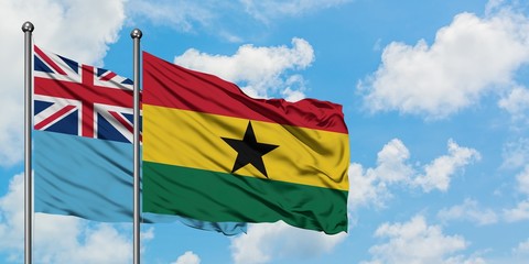 Fiji and Ghana flag waving in the wind against white cloudy blue sky together. Diplomacy concept, international relations.
