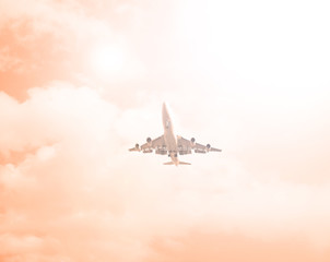Airliner against a cloudy orange sky. The sun shines.