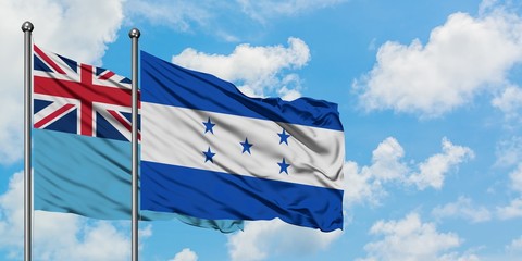 Fiji and Honduras flag waving in the wind against white cloudy blue sky together. Diplomacy concept, international relations.