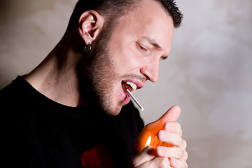 a man jokingly tries to light a stick of sucking candy