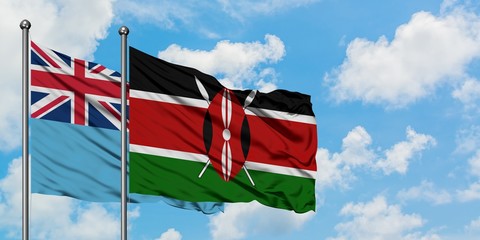 Fiji and Kenya flag waving in the wind against white cloudy blue sky together. Diplomacy concept, international relations.