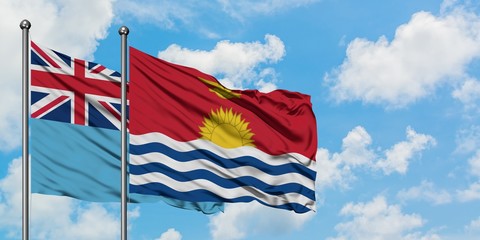 Fiji and Kiribati flag waving in the wind against white cloudy blue sky together. Diplomacy concept, international relations.