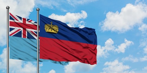 Fiji and Liechtenstein flag waving in the wind against white cloudy blue sky together. Diplomacy concept, international relations.