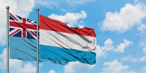 Fiji and Luxembourg flag waving in the wind against white cloudy blue sky together. Diplomacy concept, international relations.