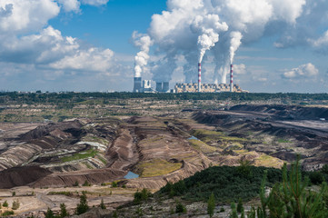 Power plant and coal mine in Bełchatów, Poland. Coal-fired power station with steam billowing from high chimneys