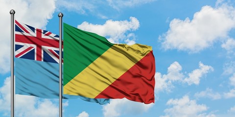 Fiji and Republic Of The Congo flag waving in the wind against white cloudy blue sky together. Diplomacy concept, international relations.