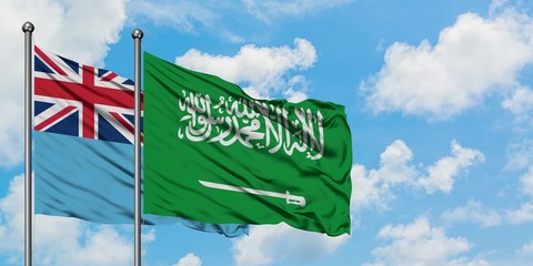Fiji and Saudi Arabia flag waving in the wind against white cloudy blue sky together. Diplomacy concept, international relations.