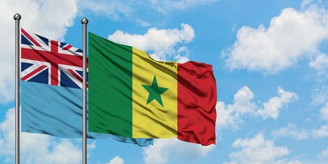Fiji and Senegal flag waving in the wind against white cloudy blue sky together. Diplomacy concept, international relations.