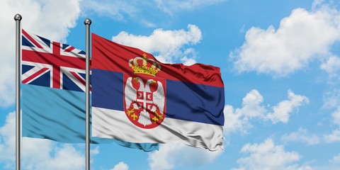 Fiji and Serbia flag waving in the wind against white cloudy blue sky together. Diplomacy concept, international relations.