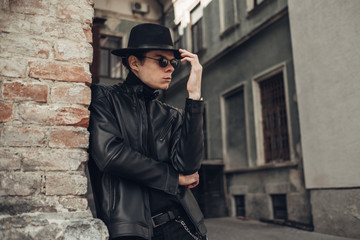 Portrait of Stylish Young Man in Black Leather Jacket and Hat