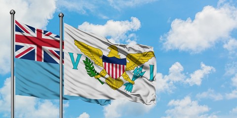 Fiji and United States Virgin Islands flag waving in the wind against white cloudy blue sky together. Diplomacy concept, international relations.