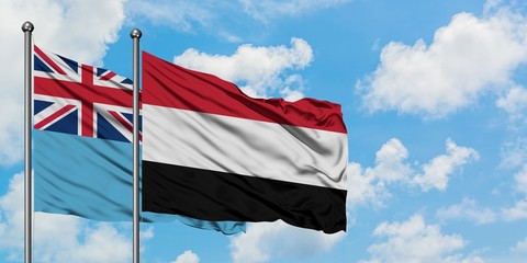 Fiji and Yemen flag waving in the wind against white cloudy blue sky together. Diplomacy concept, international relations.