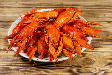 Boiled crayfish in plate on wooden table