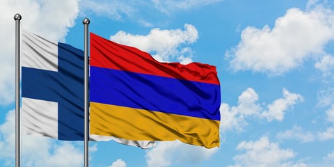 Finland and Armenia flag waving in the wind against white cloudy blue sky together. Diplomacy concept, international relations.