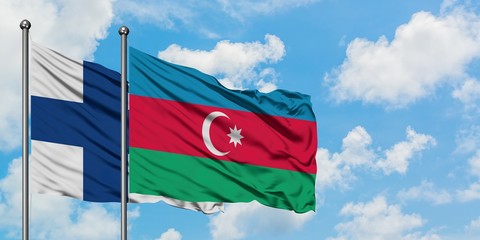 Finland and Azerbaijan flag waving in the wind against white cloudy blue sky together. Diplomacy concept, international relations.