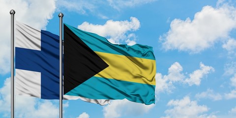Finland and Bahamas flag waving in the wind against white cloudy blue sky together. Diplomacy concept, international relations.