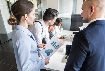 A team of young businessmen working and communicating together in an office. Corporate businessteam and manager in a meeting.