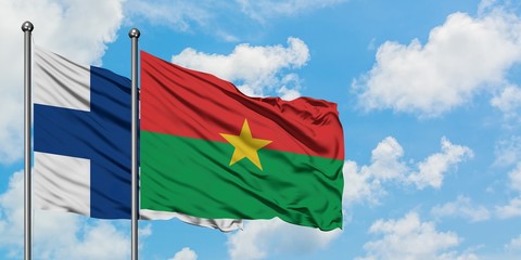 Finland and Burkina Faso flag waving in the wind against white cloudy blue sky together. Diplomacy concept, international relations.