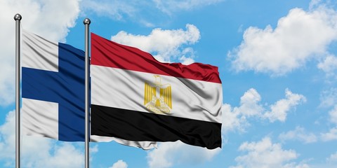 Finland and Egypt flag waving in the wind against white cloudy blue sky together. Diplomacy concept, international relations.