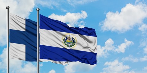 Finland and El Salvador flag waving in the wind against white cloudy blue sky together. Diplomacy...