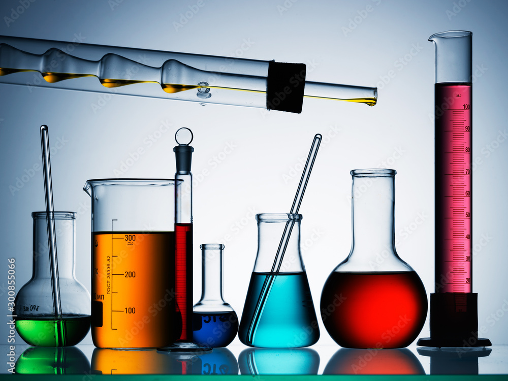 Wall mural different laboratory glassware with color liquid and with reflection