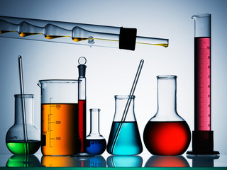 Different laboratory glassware with color liquid and with reflection