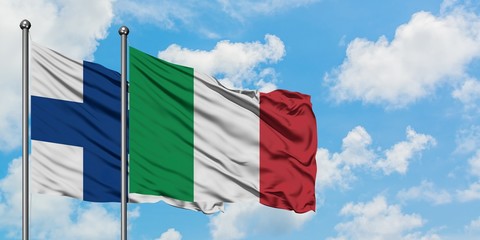 Finland and Italy flag waving in the wind against white cloudy blue sky together. Diplomacy...
