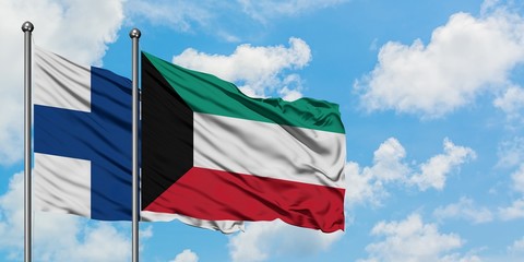 Finland and Kuwait flag waving in the wind against white cloudy blue sky together. Diplomacy concept, international relations.
