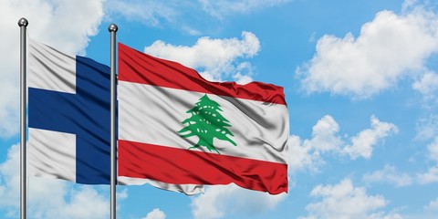 Finland and Lebanon flag waving in the wind against white cloudy blue sky together. Diplomacy concept, international relations.